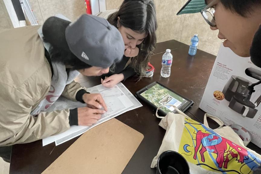 indigenous teenagers examing a map
